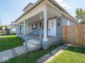 Charming covered porch with wooden deck and white columns, enhancing the curb appeal of this inviting home at 1327 E Minnesota St, Indianapolis, IN 46203