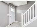 Bright entryway featuring a white front door, neutral walls, tile floor, and staircase with white railing at 1502 W 525 N, Lebanon, IN 46052