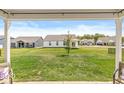 Serene view from covered patio overlooking a spacious backyard with lush green grass and neighboring homes at 17865 Haralson Row, Westfield, IN 46074