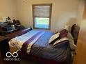 Cozy bedroom featuring comfortable furnishings, natural light, and a window overlooking the backyard at 1864 Holiday Pines Dr, Brownsburg, IN 46112