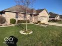Brick home with attached garage, landscaped yard, and inviting curb appeal at 1864 Holiday Pines Dr, Brownsburg, IN 46112