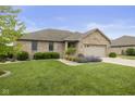 Beautifully landscaped brick home with a two-car garage, showcasing curb appeal at 1864 Holiday Pines Dr, Brownsburg, IN 46112