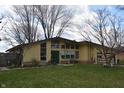 Ranch style home featuring a large front yard, big windows, and mature trees at 1936 Cunningham Rd, Indianapolis, IN 46224