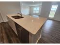 Close-up of the kitchen island featuring a stainless steel dishwasher and quartz countertops at 3181 W Keepsake Ln, Monrovia, IN 46157