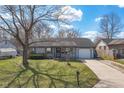 Ranch-style home featuring a covered front porch, well-manicured lawn, and driveway at 4429 Tucson Dr, Indianapolis, IN 46241