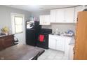 Functional kitchen featuring white cabinets, black appliances, and a view of an adjacent dining space at 4502 W 36Th St, Indianapolis, IN 46222