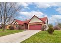 A single-Gathering, one story brick home with red roof and well-manicured lawn with an attached two-car garage at 528 Wind Skip Cir, Westfield, IN 46074