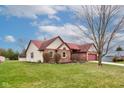 A single-Gathering, one story brick home with red roof and well-manicured lawn with an attached two-car garage at 528 Wind Skip Cir, Westfield, IN 46074