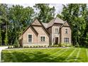 Beautiful brick home with manicured lawn, landscaped with trees and shrubs offering plenty of shade at 552 E 82Nd St, Indianapolis, IN 46240