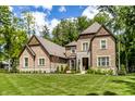 Spacious brick home with stone accents, beautiful landscaping, and a lush green lawn at 552 E 82Nd St, Indianapolis, IN 46240