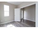 Neutral room with gray wood-look flooring, white trim, and natural light at 5786 Blue Sky Dr, Whitestown, IN 46075