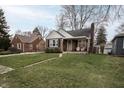 Charming brick home with manicured lawn and inviting front porch showcasing a classic design and curb appeal at 5805 Indianola Ave, Indianapolis, IN 46220