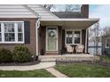 Inviting front porch with cozy seating, an interesting front door, and manicured landscaping enhance curb appeal at 5805 Indianola Ave, Indianapolis, IN 46220