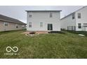 Spacious backyard with a well-maintained lawn, patio, and fire pit at 639 Rocky Meadow Dr, Greenwood, IN 46143