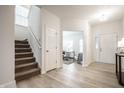 Bright and airy entryway with light wood flooring, a staircase, and a view into an office space with neutral decor at 647 Albermarle Dr, Pittsboro, IN 46167