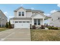 Charming two-story home featuring a two-car garage, covered porch with seating, and well-maintained landscaping at 6630 Overlander Ln, Whitestown, IN 46075