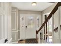 Bright foyer with a white door, decorative glass, staircase and neutral walls at 6820 W Forest Brook Dr, Fountaintown, IN 46130