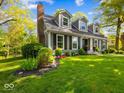 Charming home with a manicured lawn, dormer windows, gray siding, and a brick chimney at 6820 W Forest Brook Dr, Fountaintown, IN 46130