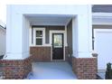 Inviting covered front porch with brick columns and a stained-glass front door at 735 Locust Dr, Danville, IN 46122