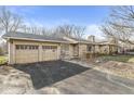 View of the two-car garage and entrance of a single-story home with an asphalt driveway at 8606 Manderley Dr, Indianapolis, IN 46240