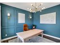 Stylish office space with wood desk, designer lighting, blue accent wall and neutral rug at 950 Edmonds Pl, Greenwood, IN 46143