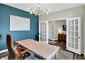 Bright home office with blue accent wall, modern lighting, and white French doors at 950 Edmonds Pl, Greenwood, IN 46143