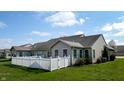 Image shows fenced backyard with lush grass and beautiful blue sky at 1304 Vicksburg S Dr, Greenwood, IN 46143