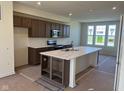 Open kitchen boasts a large island with sleek countertops, dark wood cabinets, and stainless steel appliances at 14539 Hanford Ln, Carmel, IN 46032