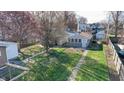 Aerial view of the backyard shows a spacious lawn, a brick walkway, and mature trees at 1521 Pleasant St, Indianapolis, IN 46203