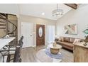 Cozy living room with a leather sofa, round coffee table, spiral staircase, and ample natural light at 307 Baywood Ct # 67, Noblesville, IN 46062