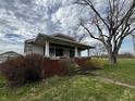 Quaint home featuring a cozy front porch with brick trim and well-maintained landscaping in a serene setting at 3179 W 400 N, Fairland, IN 46126