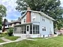 Charming two-story home featuring a screened-in porch and a classic brick chimney at 3601 Carrollton Ave, Indianapolis, IN 46205