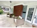 Inviting screened porch with chairs, a small table, and a view of the yard at 3601 Carrollton Ave, Indianapolis, IN 46205