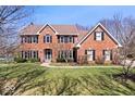 Charming brick home with a well-maintained lawn, symmetrical design, and mature trees providing shade and character at 3976 Bent Tree Ln, Greenwood, IN 46143