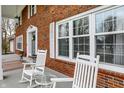 Close-up of a lovely porch with rocking chairs, large windows, and brick facade at 40 Twinshore Ct, Carmel, IN 46033