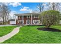 Gorgeous brick home with a manicured lawn, stone walkway, and mature landscaping at 40 Twinshore Ct, Carmel, IN 46033