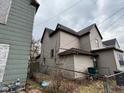 View of the side and rear of the home, with a chain link fence and an overcast sky at 413 W 8Th St, Muncie, IN 47302