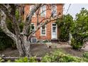 Charming red brick home featuring a white front door, mature trees, and professional landscaping at 424 E Vermont St, Indianapolis, IN 46202