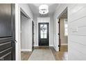 Bright entryway features hardwood floors, a decorative light fixture, and stylish doors at 4915 E 79Th St, Indianapolis, IN 46250