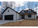 New construction modern farmhouse with a black garage door, and coordinating window and roof trim at 5123 Oak Ridge Pl, Columbus, IN 47201