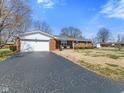 Brick home with attached garage and dark asphalt driveway at 5240 Magnolia Dr, Columbus, IN 47203