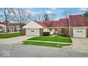 Pleasant single-story home with an attached garage and verdant front lawn at 5453 Happy Hollow # 73, Indianapolis, IN 46268