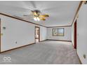Bright living room with neutral carpet, ceiling fan, and wood trim at 5453 Happy Hollow # 73, Indianapolis, IN 46268