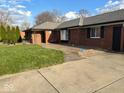 Cozy brick home with a well-kept lawn and welcoming covered porch, perfect for relaxing outdoors at 5609 E Southern Ave, Indianapolis, IN 46203