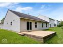 Home's back exterior with a spacious wooden deck, ideal for outdoor relaxation and entertainment at 5842 Minden Dr, Indianapolis, IN 46221