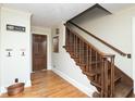 Foyer showcasing hardwood floors, a staircase, decorative hooks, and a dark wooden door at 619 Lawnwood Dr, Greenwood, IN 46142