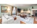 Cozy living room with hardwood floors, a brick fireplace, and comfortable sofas at 619 Lawnwood Dr, Greenwood, IN 46142