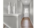 Hallway with light gray walls, white trim, wooden flooring, and modern decor at 6671 Halsey St, Zionsville, IN 46077
