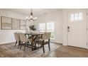 Bright dining room features a modern chandelier and a rustic wood table at 6733 Dorchester Dr, Zionsville, IN 46077