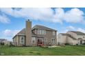 Back exterior of home featuring a well-maintained lawn, fence, and a patio area perfect for outdoor relaxation at 8536 Blue Marlin Dr, Indianapolis, IN 46239